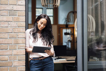 Lächelnde Geschäftsfrau mit Tablet-PC am Eingang eines Bürogebäudes - JOSEF06460