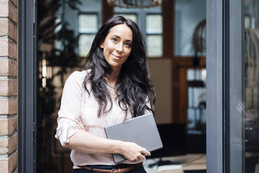 Geschäftsfrau mit Tablet-PC, die am Eingang eines Bürogebäudes steht - JOSEF06461