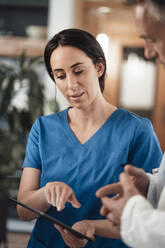 Krankenschwester erklärt Arzt über Tablet-PC im Krankenhaus - JOSEF06573