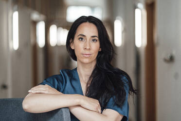 Serious businesswoman sitting on chair in coworking office - JOSEF06592