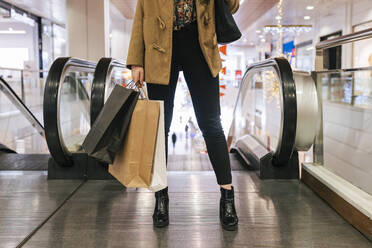 Frau mit Einkaufstaschen im Einkaufszentrum - JRVF02644