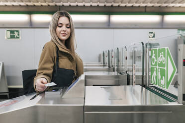 Junge Frau scannt Fahrkarte in der U-Bahn-Station - JRVF02660