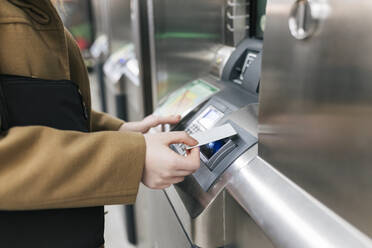 Frau benutzt Kreditkarte am Fahrkartenautomaten im Bahnhof - JRVF02662