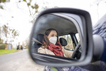 Spiegelung einer Frau mit Maske im Seitenspiegel eines Autos - BFRF02400