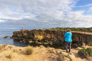 Australien, Südaustralien, Robe, Touristin fotografiert Cape Dombey Obelisk und die umliegenden Klippen - FOF12704