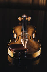 Studioaufnahme einer liegenden Geige vor schwarzem Hintergrund - DAWF02440