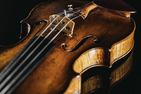 Studioaufnahme einer liegenden Geige vor schwarzem Hintergrund - DAWF02444
