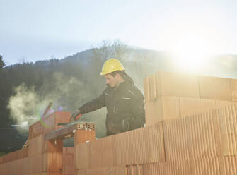 Maurer bei der Arbeit auf der Baustelle an einem sonnigen Tag - CVF01829