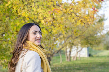 Glückliche Frau mit gelbem Schal im herbstlichen Park - EIF03145
