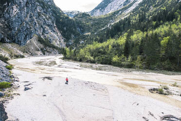 Mann steht am Flussufer im Wettersteingebirge in Bayern, Deutschland - WFF00604