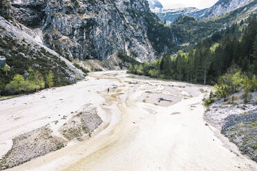 Hiker standing near river at Wetterstein mountains in Bavaria, Germany - WFF00605