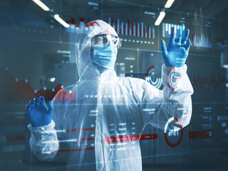 Industrial worker wearing protective workwear using transparent touch screen in clean room - CVF01850