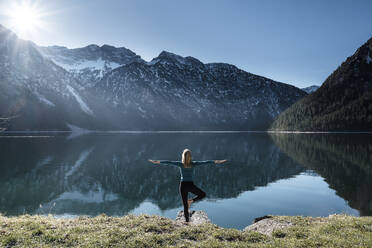 Frau übt Yoga am Plansee, Ammergauer Alpen, Reutte, Tirol, Österreich - WFF00611