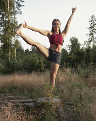 Frau übt Yoga im Wald - JBYF00091