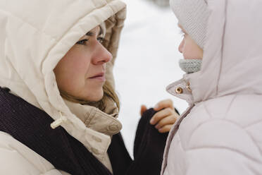 Mutter schaut Tochter im Winter an - SEAF00397