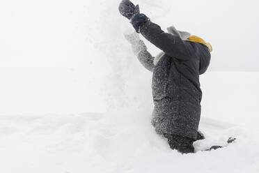 Junge genießt beim Schneewerfen im Winter - SEAF00403