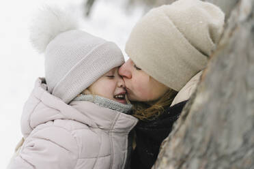 Mid erwachsene Frau küsst Tochter mit geschlossenen Augen - SEAF00411
