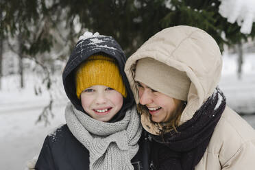 Cheerful mother looking at son in winter - SEAF00417