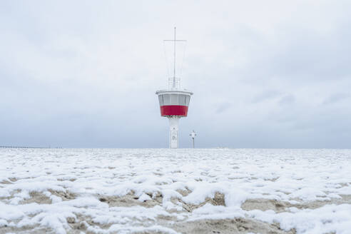 Deutschland, Schleswig-Holstein, Lübeck, Schneebedeckter Strand in Travemünde mit Aussichtsturm im Hintergrund - KEBF02192