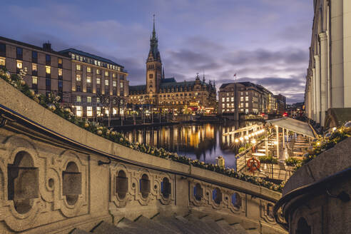 Deutschland, Hamburg, Außentreppe in der Abenddämmerung mit Kleiner Alster und Rathaus im Hintergrund - KEBF02203