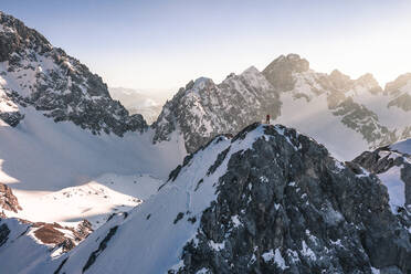 Hiker standing on snow covered mountain in winter vacation, Vorderer Tajakopf, Ehrwald, Tirol, Austria - WFF00645