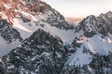 Abenteuerlustiger Mann, der bei Sonnenuntergang auf einem schneebedeckten Berg steht, Vorderer Tajakopf, Ehrwald, Tirol, Österreich - WFF00648