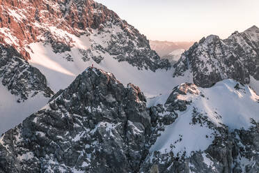 Adventurous man standing on snow covered mountain at sunset, Vorderer Tajakopf, Ehrwald, Tirol, Austria - WFF00648
