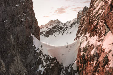 Tourist beim Spaziergang auf einem verschneiten Berg bei Sonnenaufgang, Ehrwald, Tirol, Österreich - WFF00650