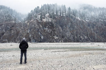 Hiker looking at mountains in winter vacation, Vorderriss, Bavaria, Germany - WFF00659