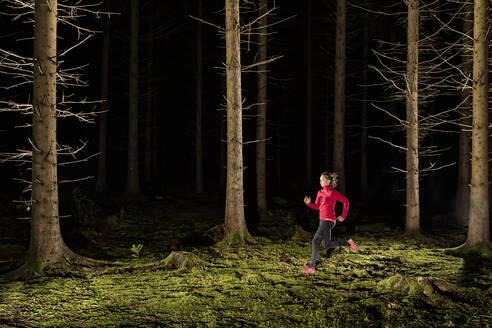 Frau läuft im dunklen Wald - STSF03137