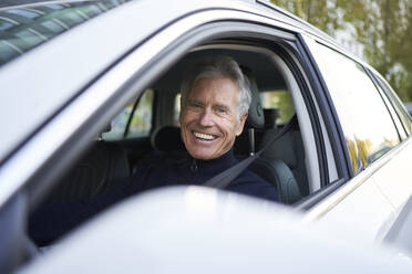 Happy senior man sitting in car - PNEF02616