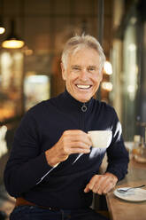 Smiling senior man having coffee in cafe - PNEF02638