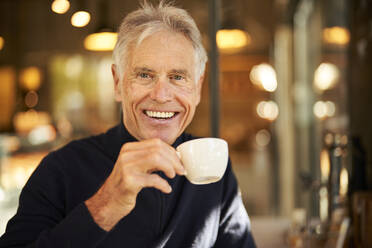 Elderly man with coffee cup in cafe - PNEF02639