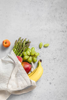 Studioaufnahme einer wiederverwendbaren Tasche, gefüllt mit reifem Obst und Gemüse - FLMF00781
