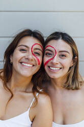 Lächelnde Frauen mit gezeichnetem Herz im Gesicht - EGHF00349