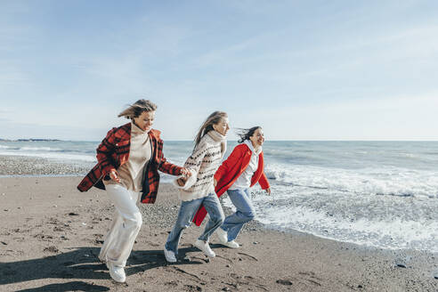 Freunde laufen auf Sand am Meer - OMIF00487