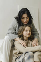 Mother sitting with daughter in living room - SEAF00448