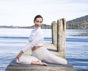 Schöne Frau übt Yoga auf dem Bootssteg - JBYF00106