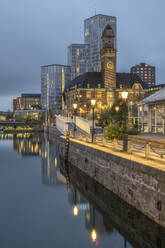 Sweden, Skane County, Malmo, City canal at dusk with World Maritime University and hotels in background - KEBF02236