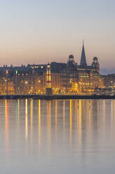 Sweden, Skane County, Malmo, Harbor lighthouse at dusk with bridge and Danske Bank in background - KEBF02239