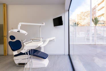 Zahnarztstuhl an einer Glaswand in einer medizinischen Klinik - DLTSF02634