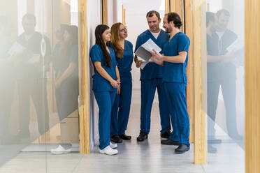 Ärzte und Krankenschwestern diskutieren gemeinsam auf dem Flur eines Krankenhauses - DLTSF02641