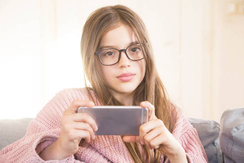 Girl with smart phone in living room at home - LVF09191