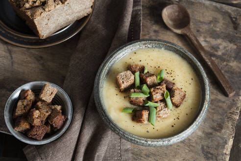 Hausgemachte Topinambursuppe garniert mit Croutons und Frühlingszwiebeln in der Schale - EVGF03990