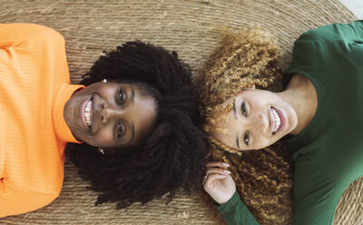 Ansicht von oben von lächelnden multirassischen Frauen Freunde liegen auf Weidenteppich auf dem Boden - ADSF33436