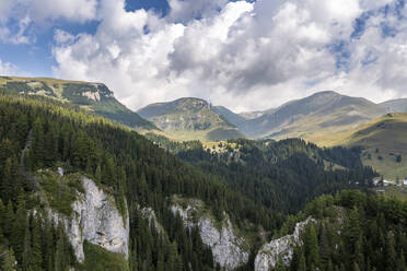 Luftaufnahme einer Bergkette an einem bewölkten Tag im Parcul Natural Bucegi, einem Nationalpark in der Nähe von Moroeni, Rumänien. - AAEF14000