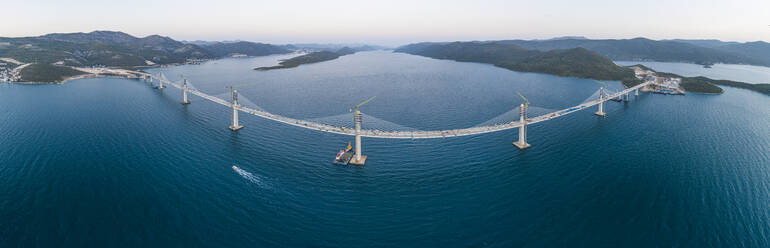 Luftaufnahme der Peljeski-Brücke, einer im Bau befindlichen Hängebahn und Schnellstraße über die Bucht von Mali Ston in Kroatien. - AAEF14120