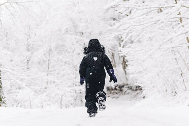 Mädchen läuft im verschneiten Winterwald - OMIF00513