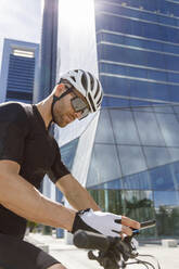 Young man using smart phone on sunny day - IFRF01524