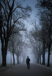 Lonely man walking on foggy avenue - FCF02025